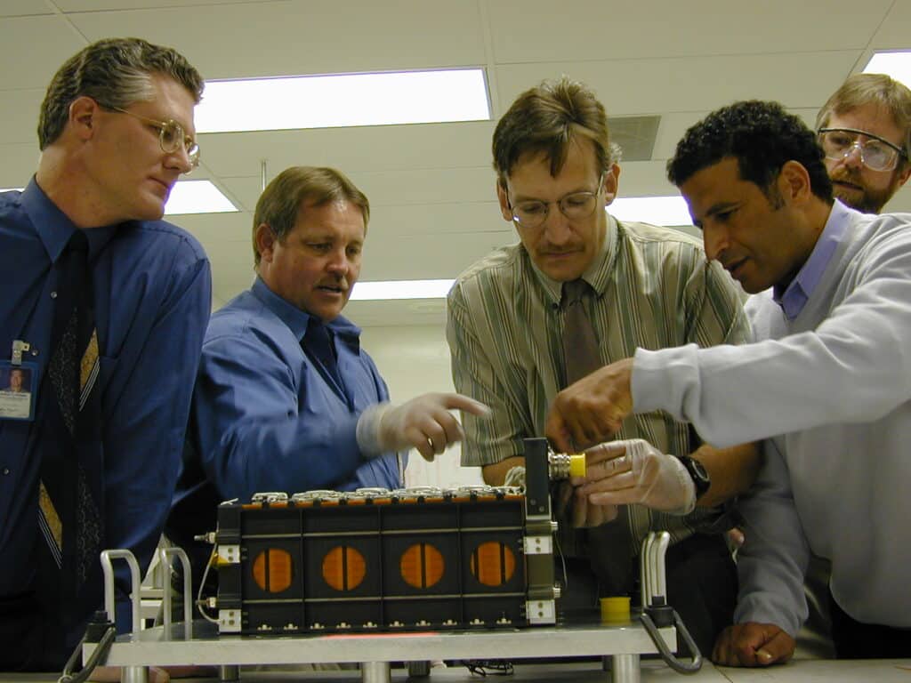 Two Eagle-Picher Project Engineers (Jeff H. and Ed L.), and Three Customers Closely Examining an Einstein Mission Battery